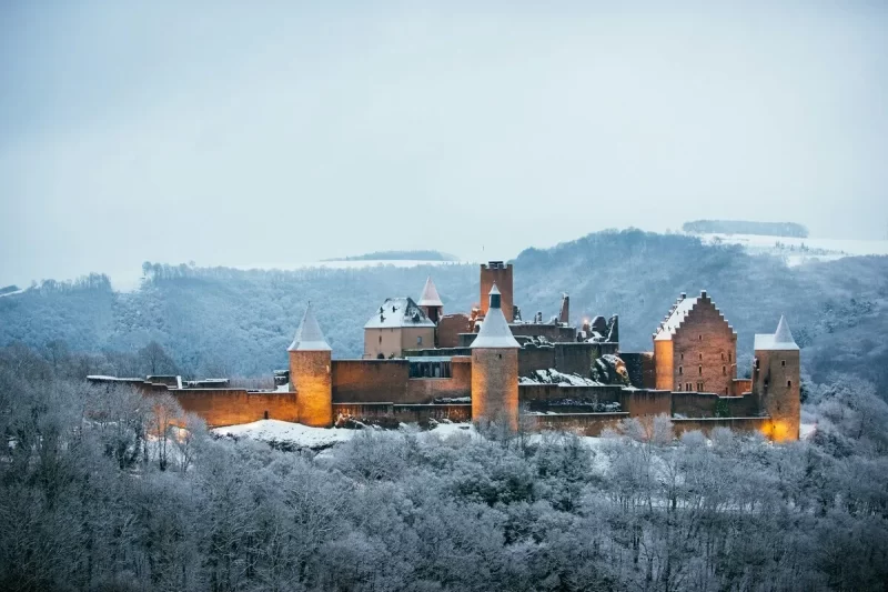 Castelo medieval coberto de neve em Luxemburgo, o país mais rico da Europa, em paisagem invernal. Arquitetura histórica.