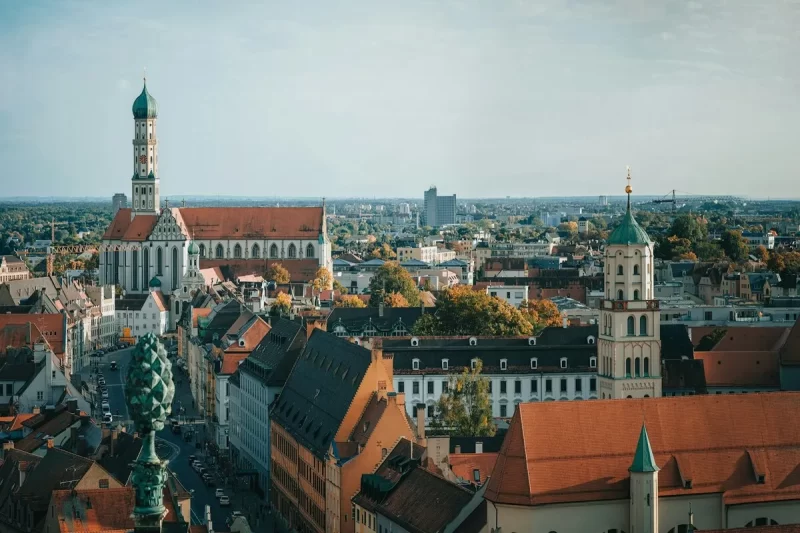 Vista panorâmica de uma cidade na Alemanha, com torres de igreja e telhados antigos, representando a beleza da Baviera.