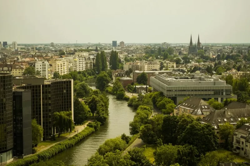 Vista aérea de Estrasburgo, na França, com rio, edifícios e a catedral ao fundo.